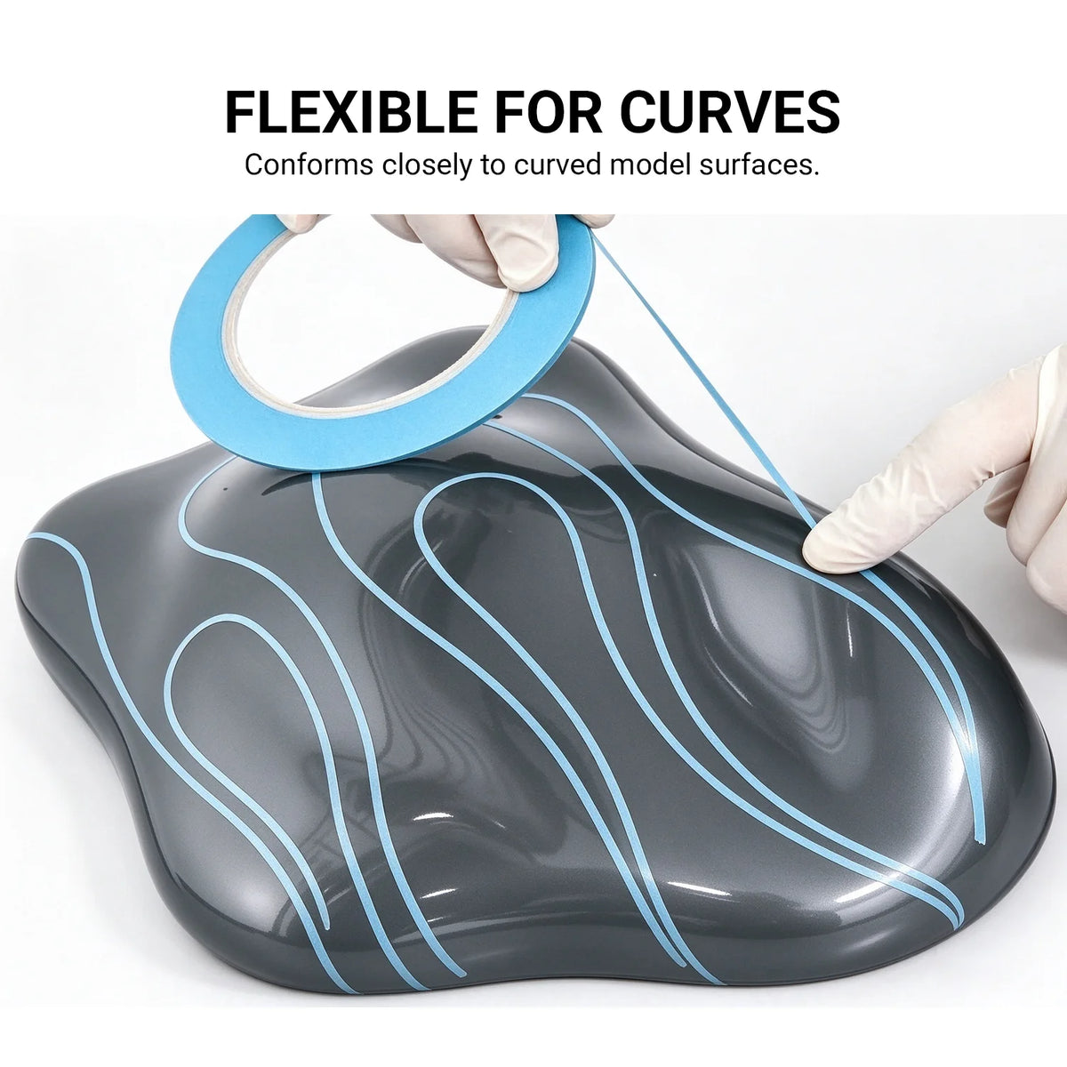 Flexible blue fine line masking tape following curved paths on a gray painted model surface